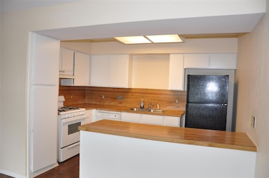 Kitchen featuring white appliances, a sink, under