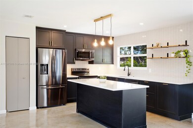 High end cabinets with quartz counters, pantry, black stainless steel appliances, garbage disposal etc.