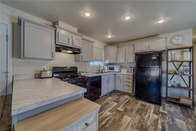 Kitchen with light countertops, dark wood-type flo