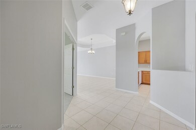 Unfurnished room with arched walkways, light tile