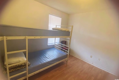 Bedroom featuring wood finished floors and baseboards