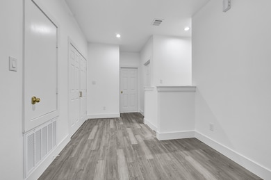 Wide second-floor landing with recessed lighting,