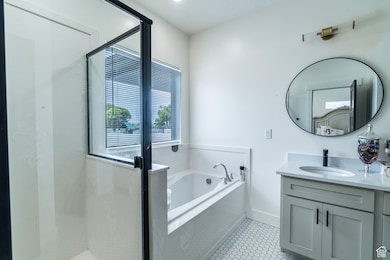 Bathroom with vanity, a garden tub, a shower stall, and tile patterned flooring