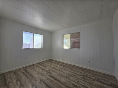 Unfurnished room with healthy amount of natural light, wood finished floors, and a textured ceiling