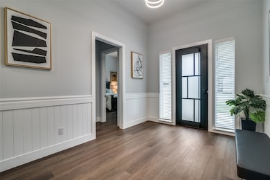 Foyer with wainscoting and dark wood finished floors