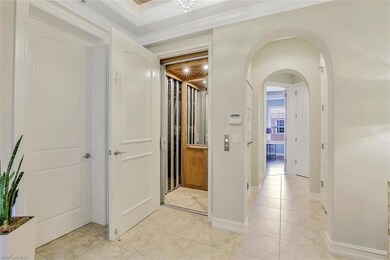 Hall featuring light tile flooring and crown moldi