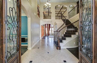 Elegant entryway features double doors with intric