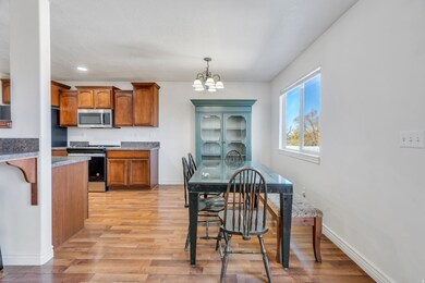 Kitchen featuring brown cabinets, appliances with stainless steel finishes, light wood-type flooring, a chandelier, and recessed lighting