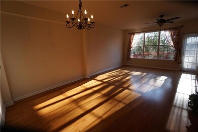 Spare room with plenty of natural light, a chandelier, and wood finished floors