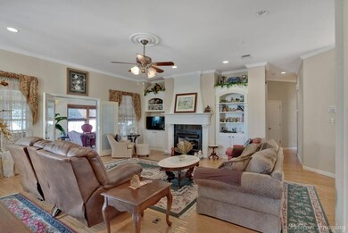 Living room with crown molding, light hardwood / w