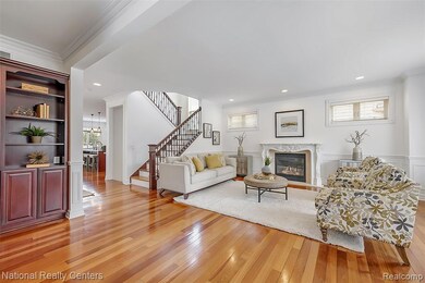 Living area with crown molding, light wood finished floors, stairs, a premium fireplace, and recessed lighting