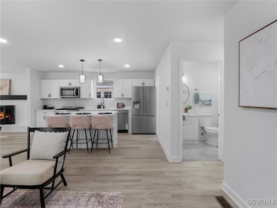 Kitchen with white cabinets, a center island, appl