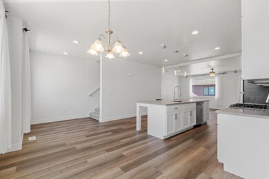 Kitchen featuring white cabinetry, pendant lighting, light wood-style flooring, an island with sink, and recessed lighting
