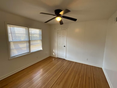 Unfurnished room featuring ceiling fan and hardwoo