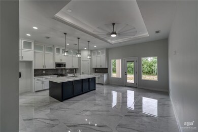 Kitchen with baseboards, marble finish floor, appliances with stainless steel finishes, and backsplash