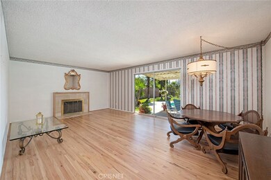 Living room highlighted by refinished original hardwood floor and warmed by the fireplace