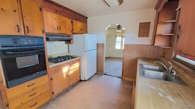 Kitchen featuring white refrigerator, sink, light