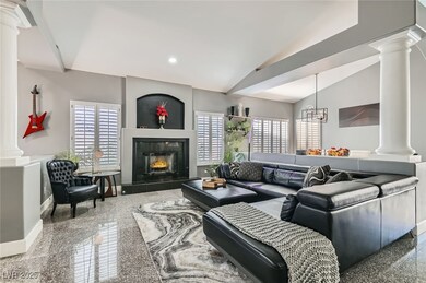 Living room with ornate columns, vaulted ceiling,