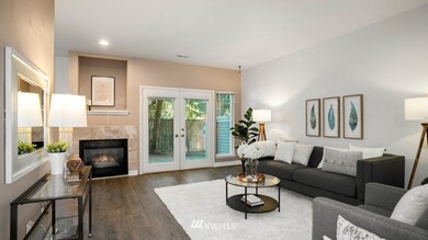 Further inside you can see you're welcomed into the large Living Room which offers a cozy gas fireplace and french door access to private patio and view of green space.