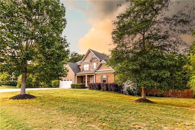 View of front of house with fence, a garage, brick