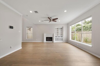 Unfurnished living room featuring plenty of natural light, light wood finished floors, recessed lighting, a tile fireplace, and crown molding
