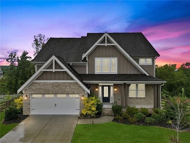 Craftsman-style home featuring board and batten siding, a lawn, and brick siding