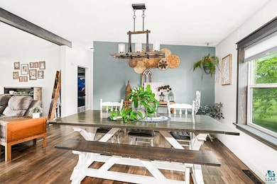Dining space with wood finished floors, a chandelier, and baseboards