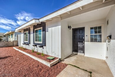 View of exterior entry with stucco siding and fenc
