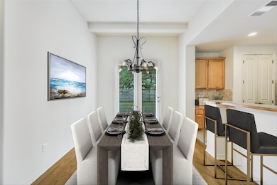 Dining space featuring beamed ceiling, light wood