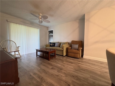 Living area with wood finished floors, ceiling fan