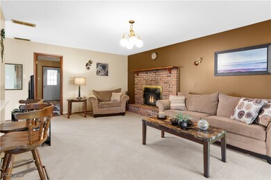Living area with a chandelier, carpet floors, and a fireplace
