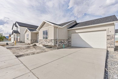 View of front facade with stone siding, roof with shingles, driveway, and stucco siding