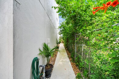 This photo shows a narrow side walkway beside a ho