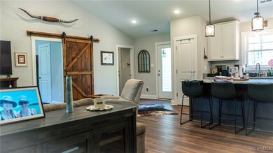 Kitchen with a kitchen bar, visible vents, dark wo