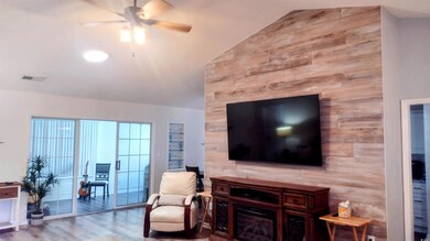 Living room featuring ceiling fan, wood finished floors, and high vaulted ceiling
