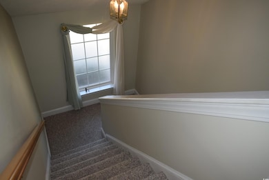 Stairway with an inviting chandelier, carpet, and 