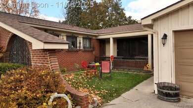 Doorway to property featuring brick siding, a lawn, and a shingled roof