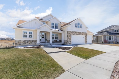 View of front of home featuring concrete driveway, board and batten siding, and stone siding