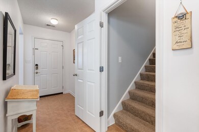 Tiled entryway featuring a textured ceiling