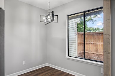 Unfurnished dining area featuring a chandelier and dark wood finished floors