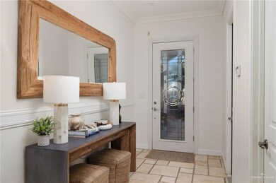 Doorway to outside with crown molding and stone tile floors