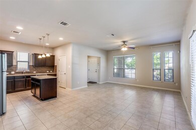 Kitchen with a kitchen island, pendant lighting, decorative backsplash, dark brown cabinets, and light tile patterned flooring