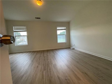 Empty room with dark wood-style floors and healthy amount of natural light