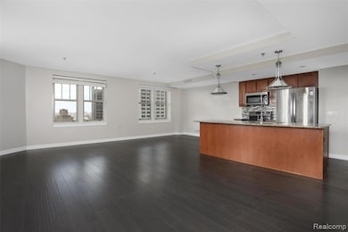 Kitchen with open floor plan, pendant lighting, light stone countertops, backsplash, and appliances with stainless steel finishes
