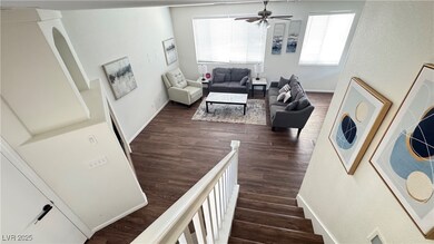 Stairway with a ceiling fan and wood finished floo