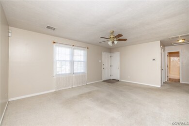 Carpeted empty room featuring a ceiling fan and na