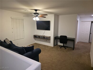 Living area with carpet, a ceiling fan, and an office area