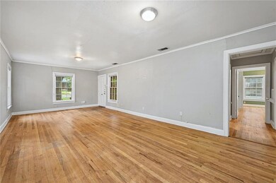 Empty room featuring attic access, crown molding,