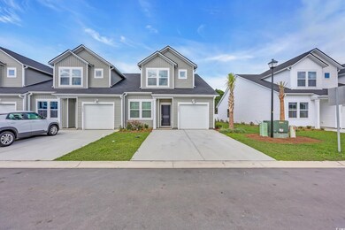 Traditional-style home with driveway, a garage, and a front lawn