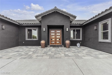 Doorway to property with a tile roof and stucco si